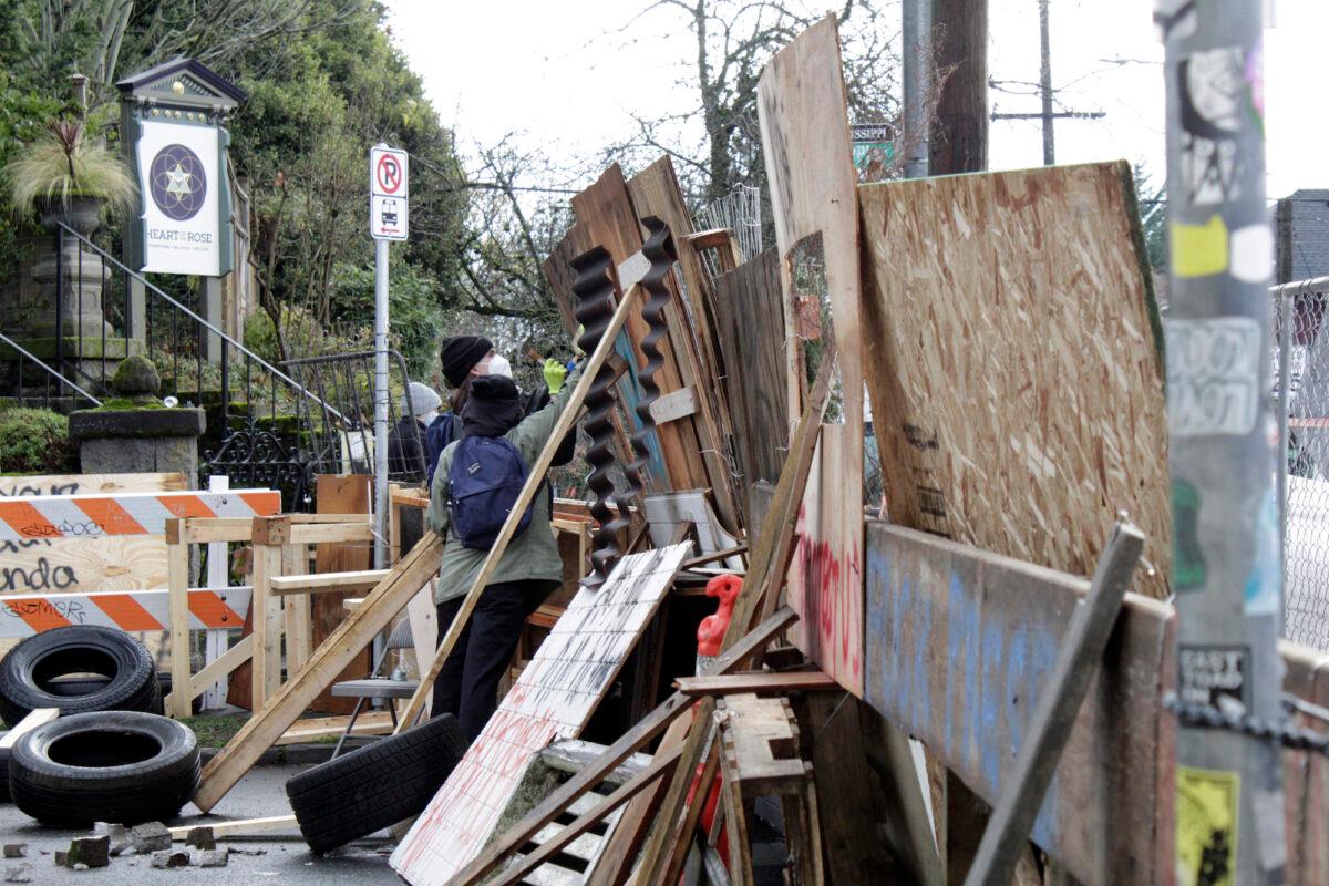 Protesters reinforce their barricades at an encampment outside a home in Portland, Ore., on Dec. 9, 2020. (Gillian Flaccus/AP Photo)