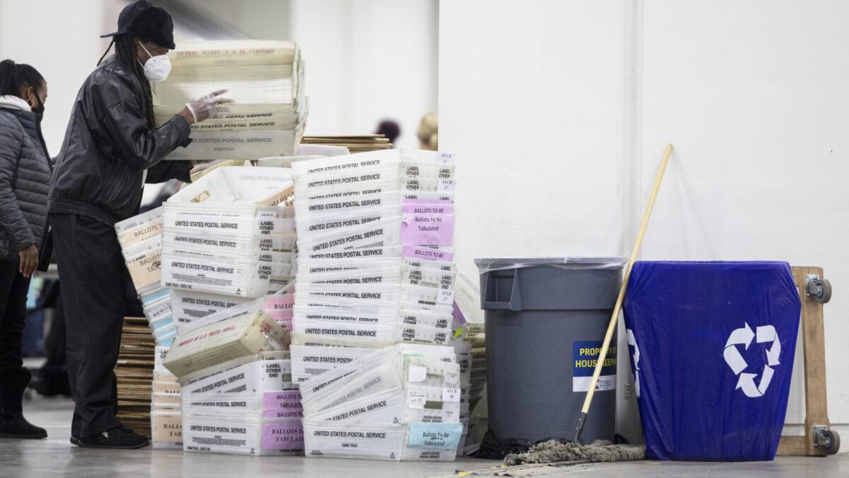 A worker with the Detroit Department of Elections helps stack empty boxes used to organize absentee ballots after nearing the end of the absentee ballot count at the Central Counting Board in the TCF Center in Detroit, on Nov. 4, 2020. (Elaine Cromie/Getty Images)