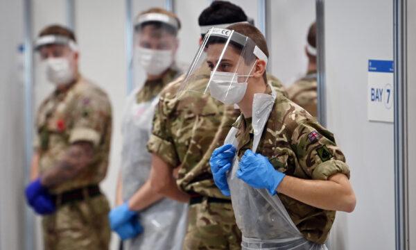 Soldiers wearing full PPE in the form of face shields, gloves, face masks and bibs wait to assist CCP virus testing at a rapid testing centre in the Liverpool exhibition centre in Liverpool, England, on November 11, 2020. (Paul ELLIS / AFP via Getty Images)