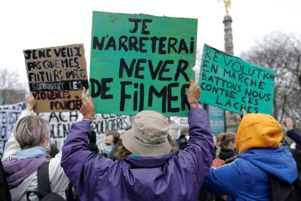 A demonstrator, center, holds a poster "I will never stop filming" during a protest on Dec.12, 2020 in Paris. (Lewis Joly/AP Photo)