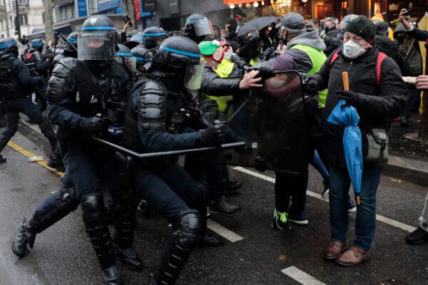 Riot police officers scuffle with demonstrators during a protest on Dec.12, 2020 in Paris. (Lewis Joly/AP Photo)