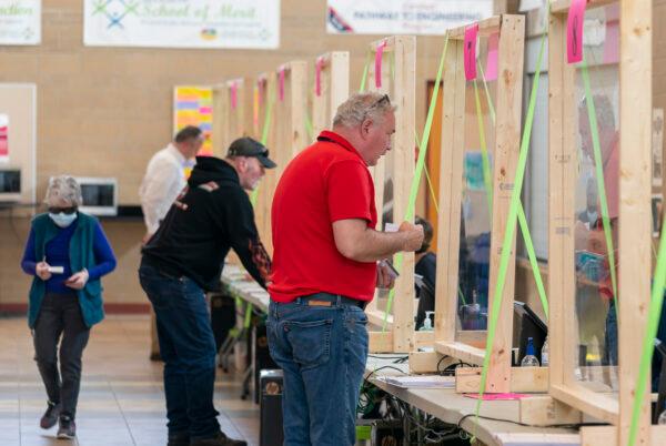 People check in to vote at a polling place in Sun Prairie, Wis., on April 7, 2020. (Andy Manis/Getty Images)