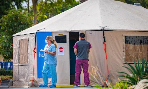 A nurse and a worker stand in front of an emergency tent set up to handle an increase in COVID-19 patients outside of Hoag Memorial Hospital in Irvine, Calif., on Dec. 11, 2020. (John Fredricks/The Epoch Times)