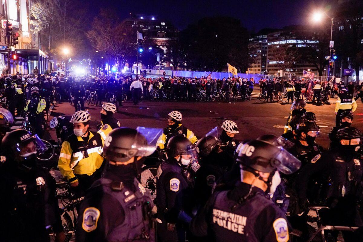 Police officers stand in formation to separate members of the Proud Boys and counter-protesters, in downtown Washington, on Dec. 12, 2020. (Erin Scott/Reuters)