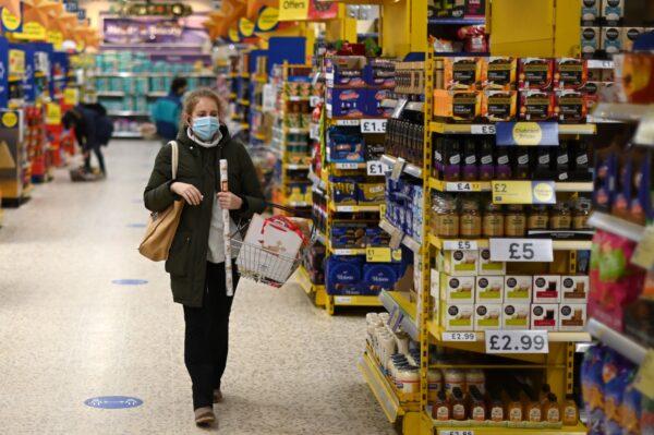 A shopper wearing a protective face covering walks the aisles of a Tesco supermarket in London, on Dec. 14, 2020. (Daniel Leal-Olivas/AFP via Getty Images)
