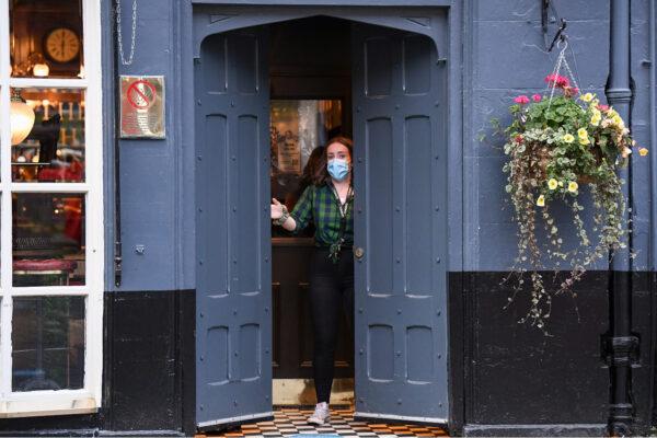 A member of staff closes The Beehive pub in the Grassmarket following last orders in Edinburgh, Scotland at 6 p.m. on Oct. 9, 2020. (Jeff J Mitchell/Getty Images)