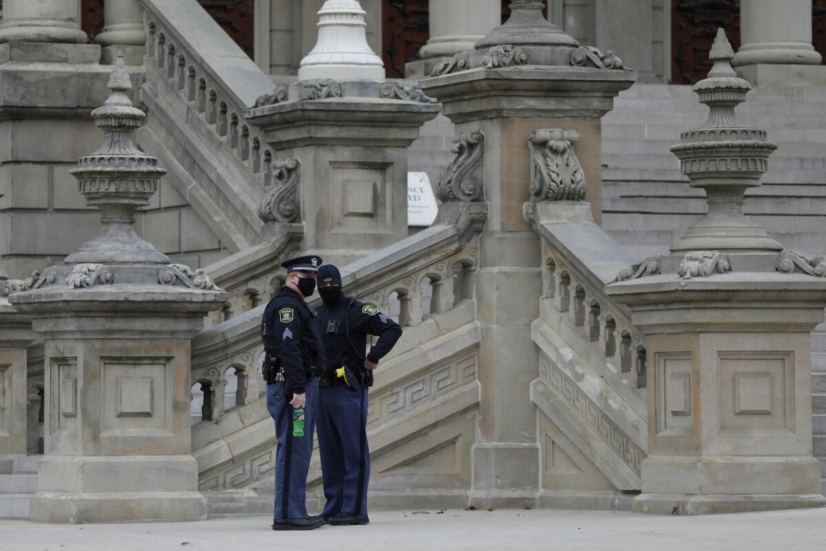 Police officers check the perimeters as Michigan electors gather to cast their votes for the presidential election at the Michigan State Capitol in Lansing, Mich., on Dec. 14, 2020. (Emily Elconin/Reuters)