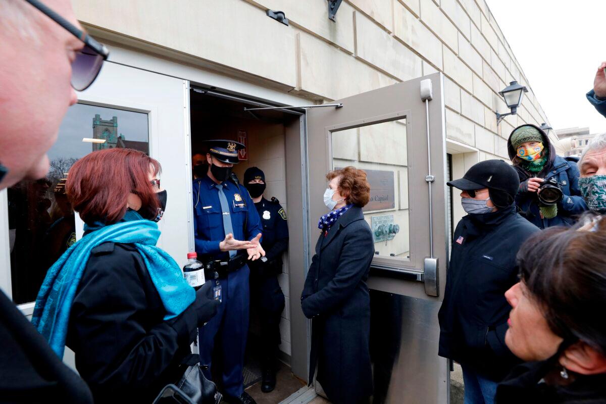 Electors from the GOP are denied entry to the Michigan Capital as the Electors from the Democratic Party cast their ballot in Lansing, Mich., on Dec. 14, 2020. (Jeff Kowalsky/AFP via Getty Images)