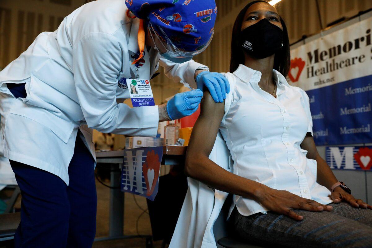 Nurse Cheryl Birmingham administers the Pfizer-BioNTech COVID-19 vaccine to registered nurse La Tanya Forbes at Memorial Healthcare System facility in Miramar, Fla., on Dec. 14, 2020. (Marco Bello/Reuters)