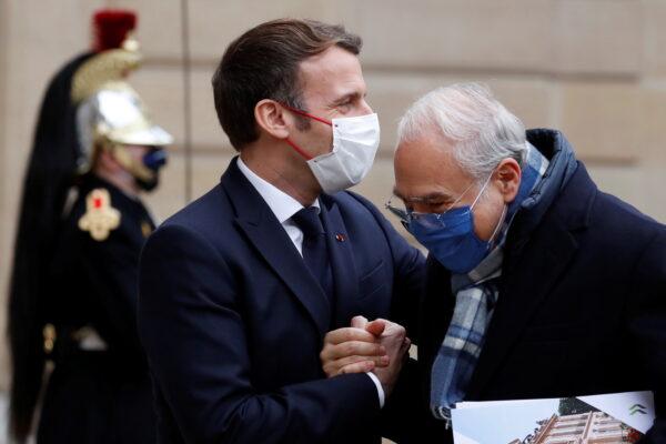 French President Emmanuel Macron welcomes Organization for Economic Cooperation and Development Secretary General Angel Gurria at the Elysee Palace in Paris, on Dec. 14, 2020. (Christian Hartmann/Reuters)