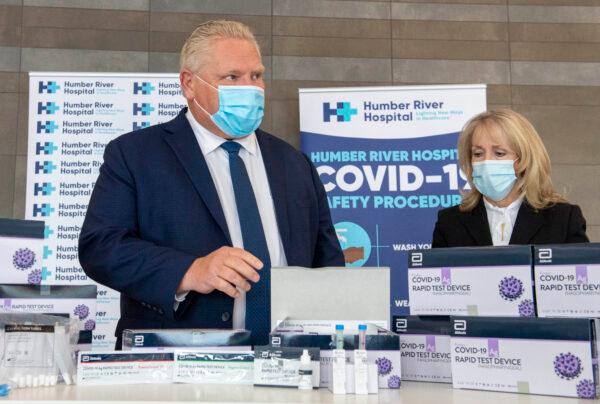 Ontario Premier Doug Ford and Long-Term Care Minister Merrilee Fullerton listen as they are briefed on COVID-19 Rapid Test Device kits at Humber River Hospital in Toronto on Nov. 24, 2020. (Frank Gunn/The Canadian Press)