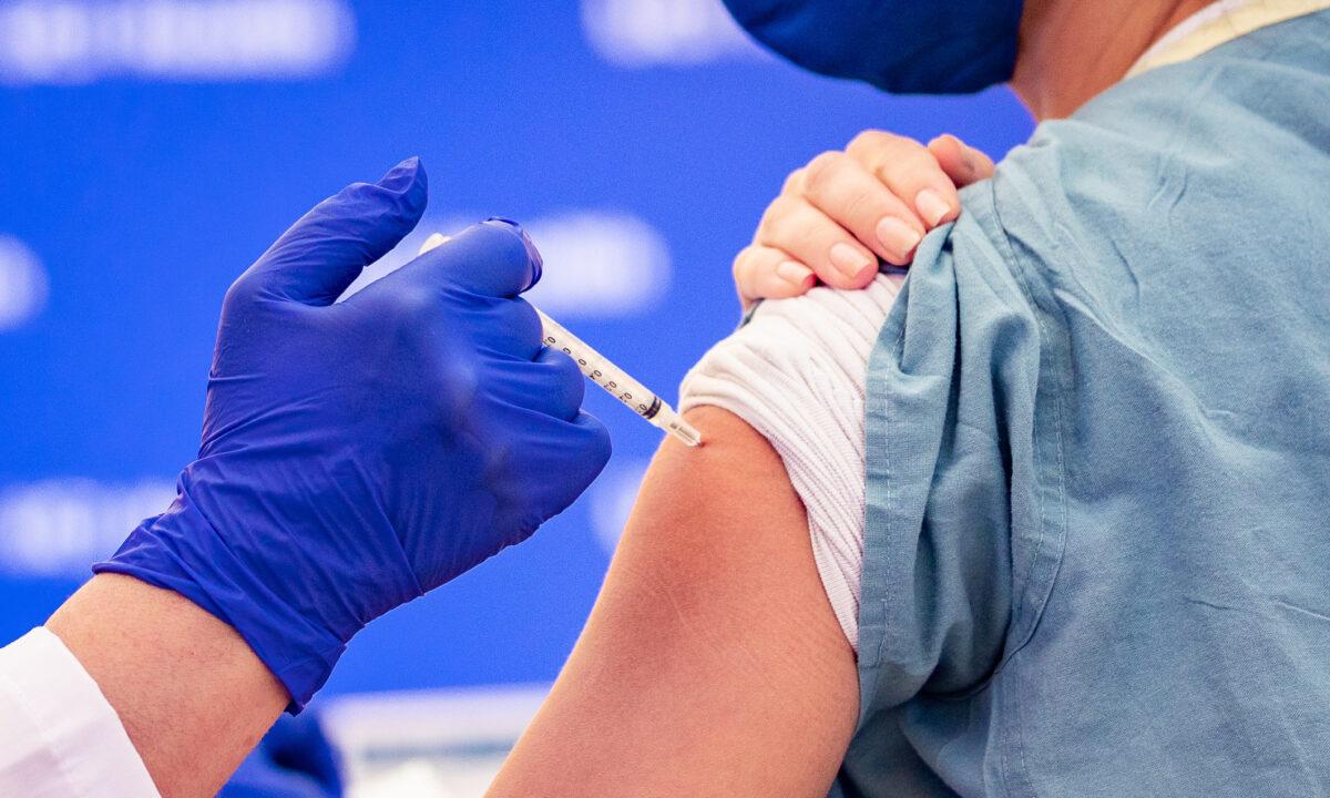 A health care worker at St. Joseph Hospital receives one of Orange County's first COVID-19 vaccine injections in Orange, Calif., on Dec. 16, 2020. (John Fredricks/The Epoch Times)