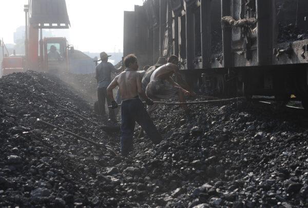 Chinese miners unload coal from a train in Hefei, in eastern China's Anhui Province on Aug. 4, 2010. (STR/AFP via Getty Images)