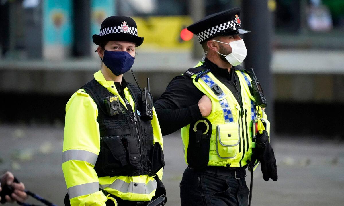 Police officers wear masks as they patrol the city centre in Manchester, England, on Oct. 20, 2020. (Christopher Furlong/Getty Images)