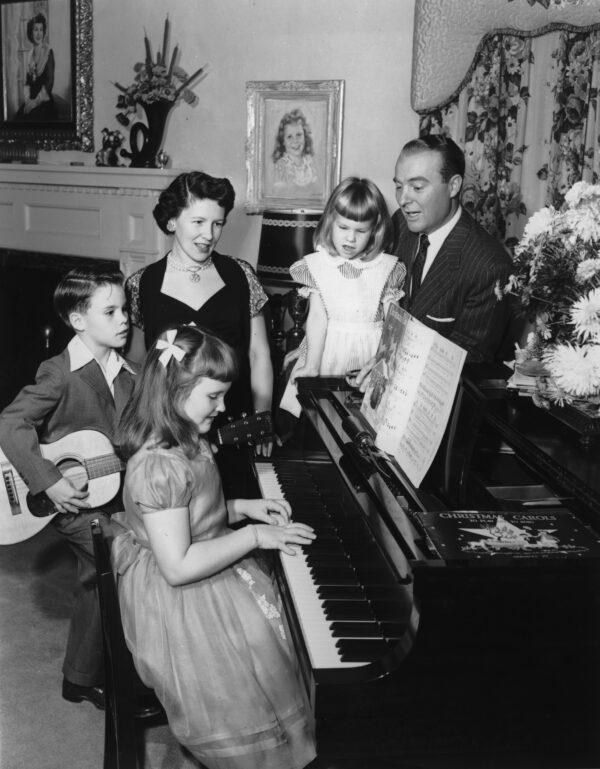 Time to revive an old tradition: family singing. Circa 1955, American television show host Ralph Edwards and his family sing songs around a piano in their home. (Hulton Archive/Getty Images)