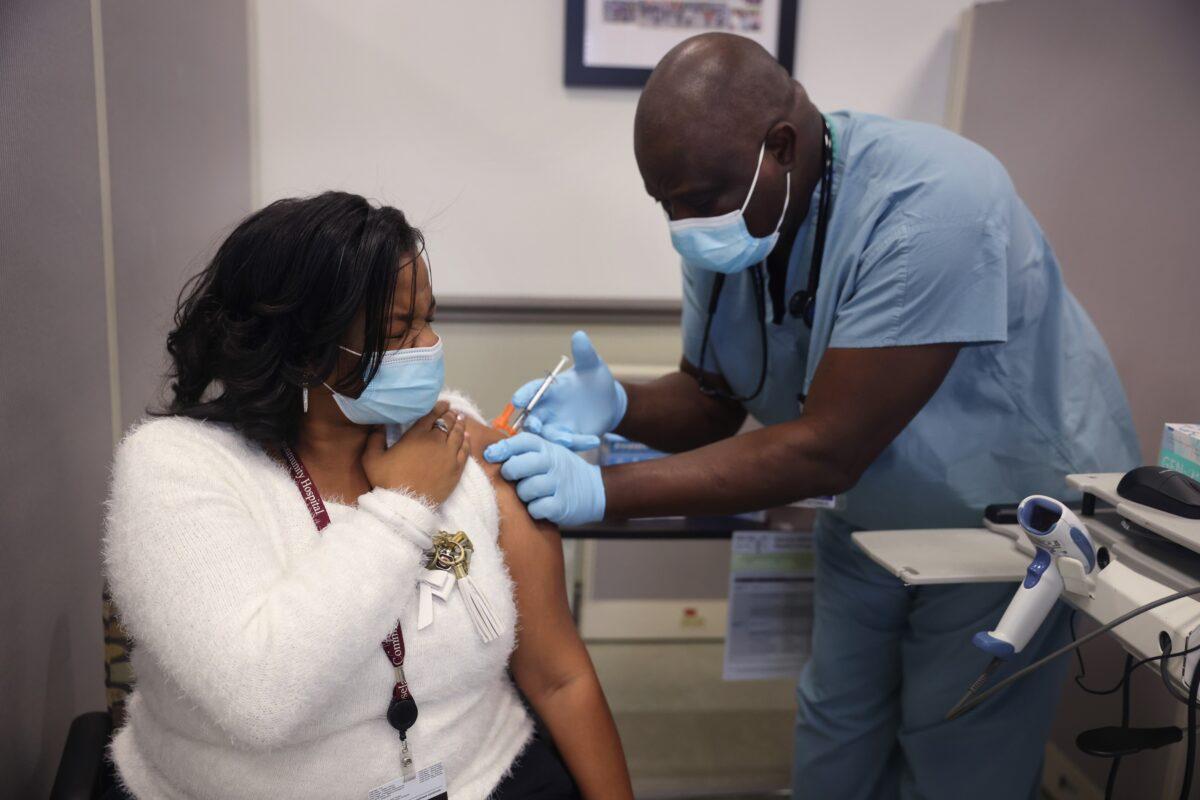 Christianna Tucker gets a COVID-19 vaccine shot from Anthony Oyetola at Roseland Community Hospital in Chicago, Ill., on Dec. 18, 2020. (Scott Olson/Getty Images)