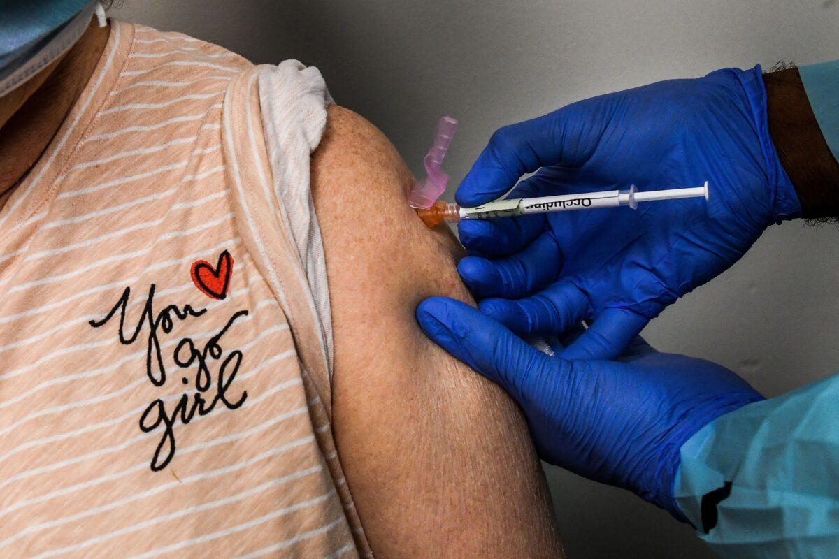 Healthcare worker Daisie Esseie receives a Pfizer-BioNtech COVID-19 vaccine from nurse practitioner Hari Leon Joseph at the Research Centers of America in Hollywood, Fla., on Dec. 18, 2020. (Chandan Khanna/AFP via Getty Images)