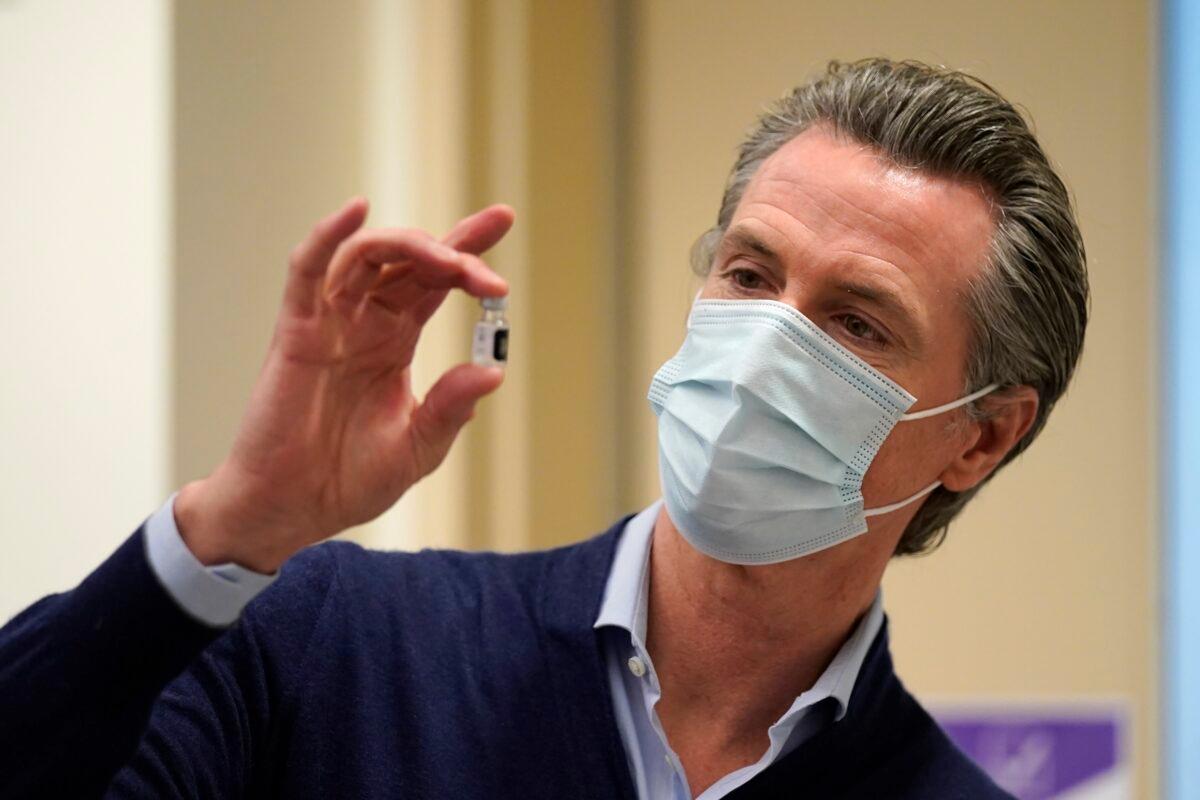 California Gov. Gavin Newsom holds up a vial of the new COVID-19 vaccine at Kaiser Permanente Los Angeles Medical Center in Los Angeles, Calif., on Dec. 14, 2020. (Jae C. Hong/Pool/Getty Images)
