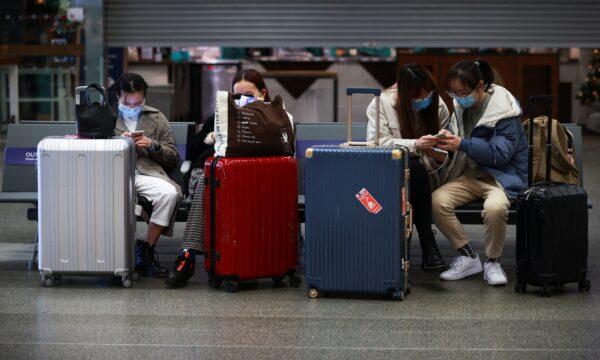 Travellers with suitcases sit at the Eurostar terminal at St Pancras International, as EU countries impose a travel ban from the UK following the coronavirus disease (COVID-19) outbreak, in London, Britain, on Dec. 21, 2020. (Hannah McKay/Reuters)