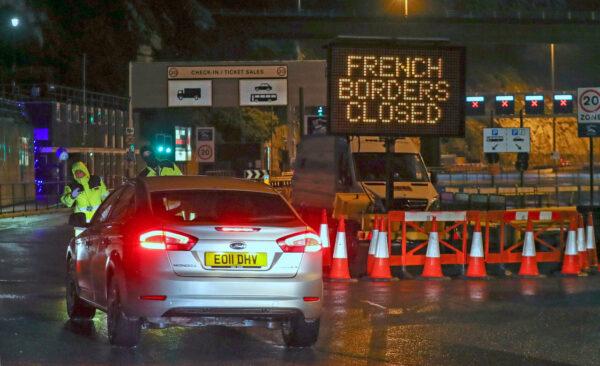 Police and port staff turn away a vehicle from the Port of Dover in Kent, England which has been closed after the French government's announcement, on Mon. Dec. 21, 2020. (Steve Parsons/PA via AP)