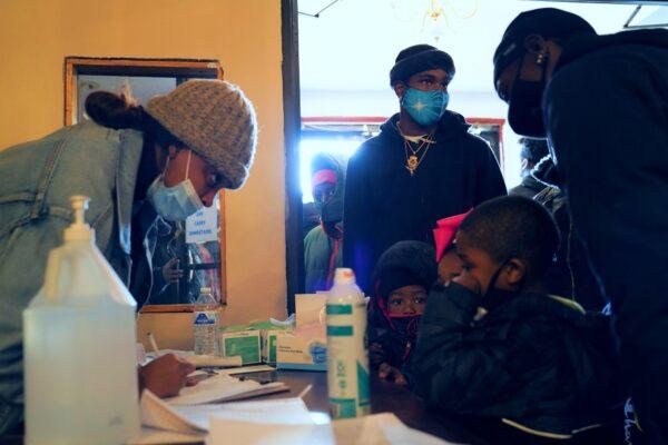 People line up to receive help through the Ruby's Roses charity event at Lively Stone Missionary Baptist Church in Chicago, on Dec. 19, 2020. (Cara Ding/The Epoch Times)