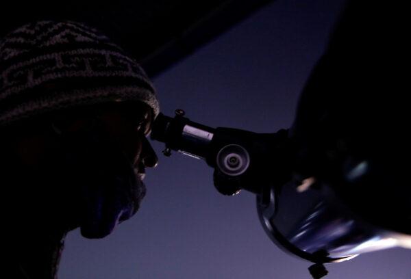A man observes the closest visible conjunction of Jupiter and Saturn in 400 years, through a telescope in Kathmandu, Nepal, Dec. 21, 2020. (Navesh Chitrakar/Reuters)