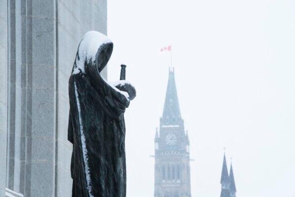 The Peace Tower of Parliament Hill is seen past the Statue of Justice at the Supreme Court of Canada in Ottawa in a file photo. (The Canadian Press/Sean Kilpatrick)