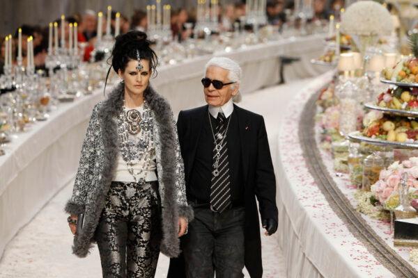 German fashion designer Karl Lagerfeld with British model Stella Tennant (L) acknowledges applause at the end of the presentation of his Paris-Bombay collection for Chanel, presented at the Grand Palais in Paris, on Dec. 6, 2011. (Remy de la Mauviniere/AP Photo)