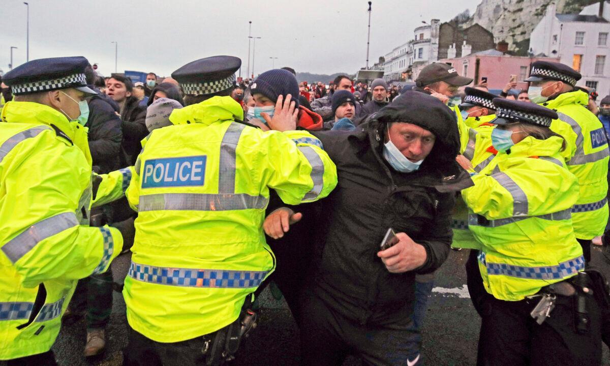 Lorry drivers argue with police holding them back at the entrance to the Port of Dover in Kent, England, on Dec. 23, 2020. (Steve Parsons/PA via AP)