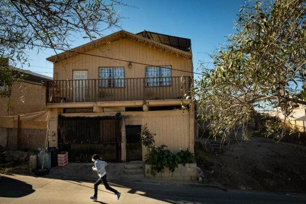  A man runs past Casas De Dios foster home in Tijuana, Mexico, on Dec. 19, 2020. (John Fredricks/The Epoch Times)