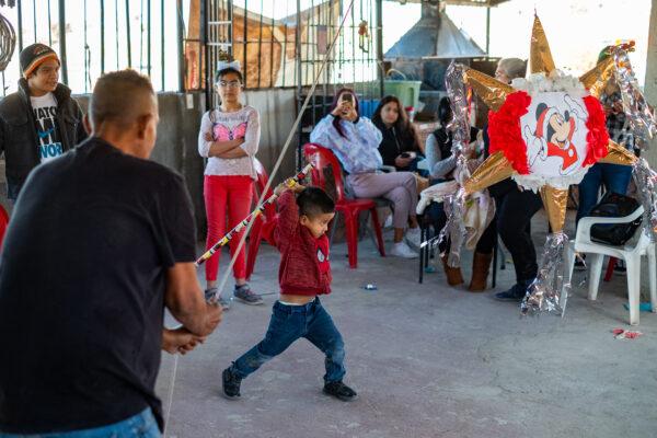 Children play with a pinata at Casas De Dios foster home in Tijuana, Mexico, on Dec. 19, 2020. (John Fredricks/The Epoch Times)