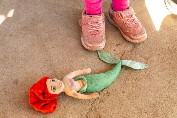 A child stands near her doll at Casas De Dios foster home in Tijuana, Mexico, on Dec. 19, 2020. (John Fredricks/The Epoch Times)