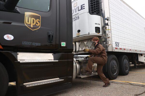  A UPS worker hooks a UPS truck to a trailer containing shipments of the Pfizer And BioNTech COVID-19 vaccine at the Capital Region International Airport in Lansing, Mich., on Dec. 13, 2020. (Rey Del Rio/Getty Images)