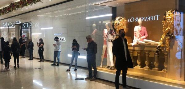 Shoppers wait to enter the Chanel store at the South Coast Plaza mall in Costa Mesa, Calif., on Dec. 23, 2020. (Alex Murashko/The Epoch Times)