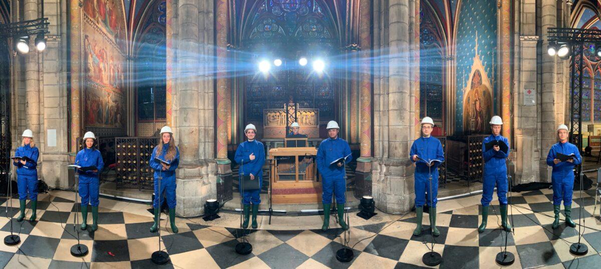 The Notre Dame Cathedral choir, wearing hard hats and protective suits, record a Christmas concert inside Notre Dame Cathedral in Paris, on Dec. 19, 2020. The concert will be broadcasted on French television on Christmas. (MSNDP/Musique Sacree à Notre-Dame de Paris via AP)