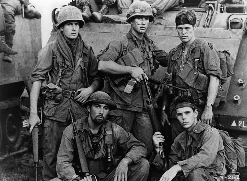 (L–R) (standing) Charlie Sheen, Tom Berenger, Willem Dafoe, (seated) Francesco Quinn, and Kevin Dillon on the set of “Platoon.” (Orion Pictures)