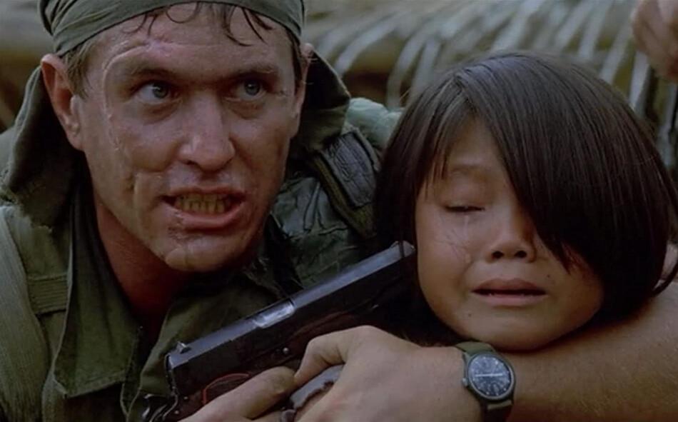 Sergeant Barnes (Tom Berenger) threatens to kill the village chief's daughter (Li Thi Van) if he doesn't get some answers, in "Platoon." (Orion Pictures)