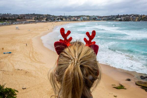 A woman wearing antlers looks at Bondi Beach in Sydney, Australia on Dec. 25, 2020. (Jenny Evans/Getty Images)