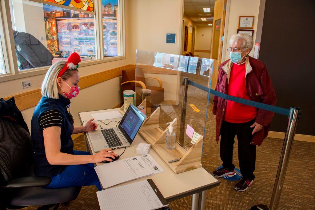 A medical assistant checks in an elderly patient to receive the COVID-19 vaccine in Boston on Dec. 24, 2020. JOSEPH PREZIOSO/AFP via Getty Images