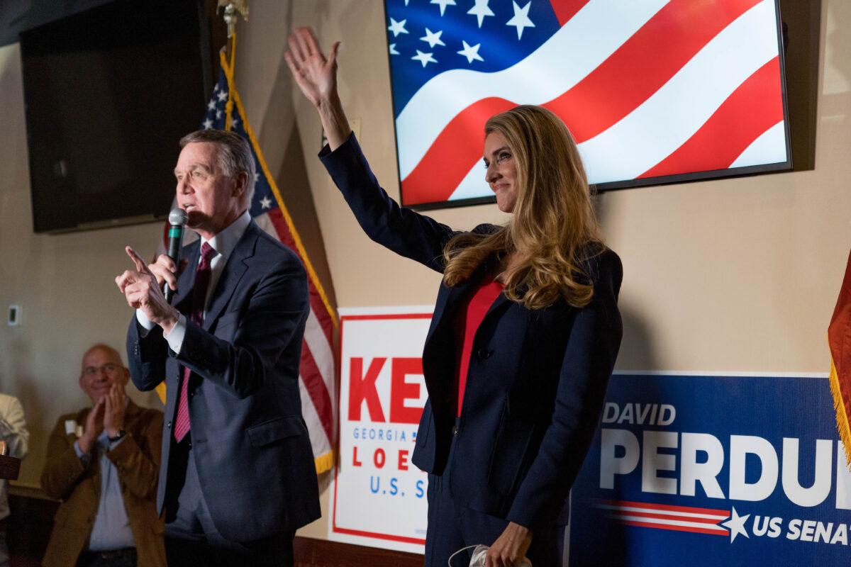 U.S. Sens. David Perdue (R-Ga.) and Kelly Loeffler (R-Ga.) speak at a campaign event to supporters at a restaurant in Cumming, Ga. on Nov. 13, 2020. (Megan Varner/Getty Images).