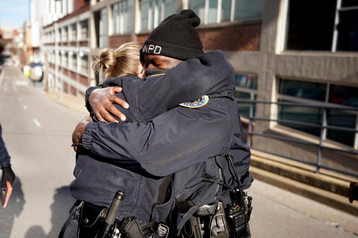 Nashville Police officers Brenna Hosey (L) and James Wells embrace after speaking at a news conference in Nashville, Tenn., on Dec. 27, 2020. (Mark Humphrey/AP Photo)