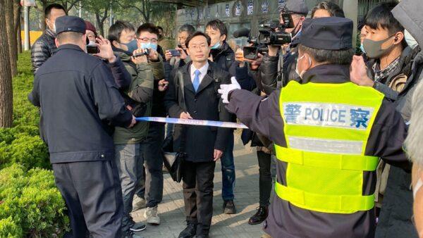 A police officer tries to stop media as a lawyer (C) of Zhang Zhan arrives at a court in Shanghai, China on Dec. 28, 2020. (Kyodo News via AP)