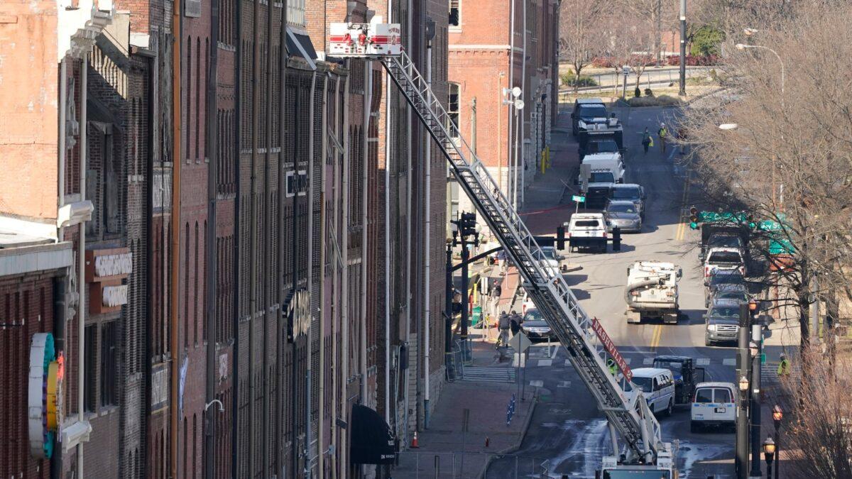 Firefighters ride in an aerial ladder as they inspect buildings damaged in a Christmas Day explosion in Nashville, Tenn., on Dec. 28, 2020. (Mark Humphrey/AP Photo)
