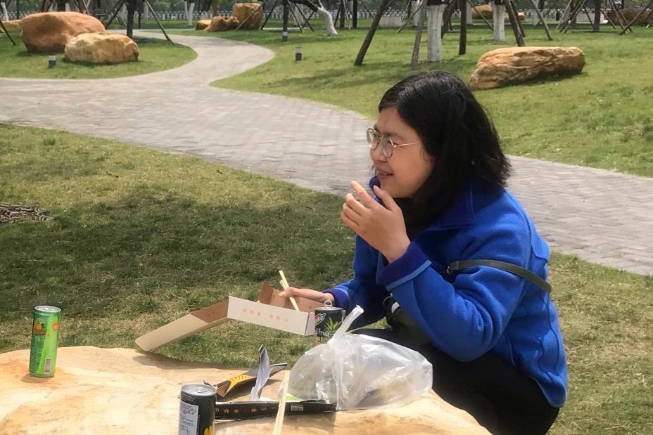 Zhang Zhan eats a meal at a park during a visit to Wuhan in central China's Hubei Province on April 14, 2020. (Melanie Wang via AP)