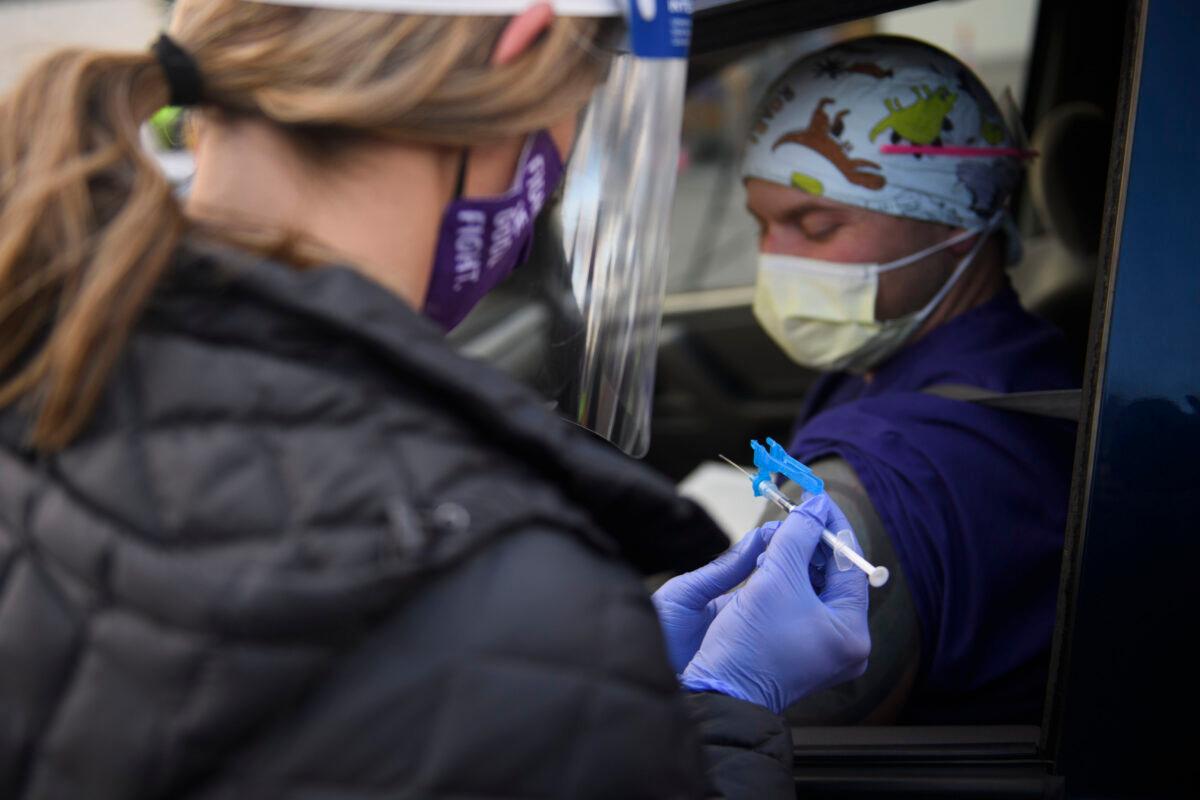 A nurse holds a syringe as she administers a COVID-19 vaccine to a health care worker in Reno, Nev., on Dec. 17, 2020. (Patrick Fallon/AFP via Getty Images)