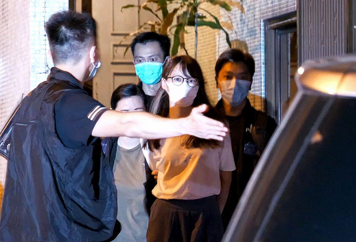 Prominent Hong Kong democracy activist Agnes Chow (C) is led away by police from her home after she was arrested under the new national security law in Hong Kong on Aug. 10, 2020. (Daniel Suen/AFP via Getty Images)