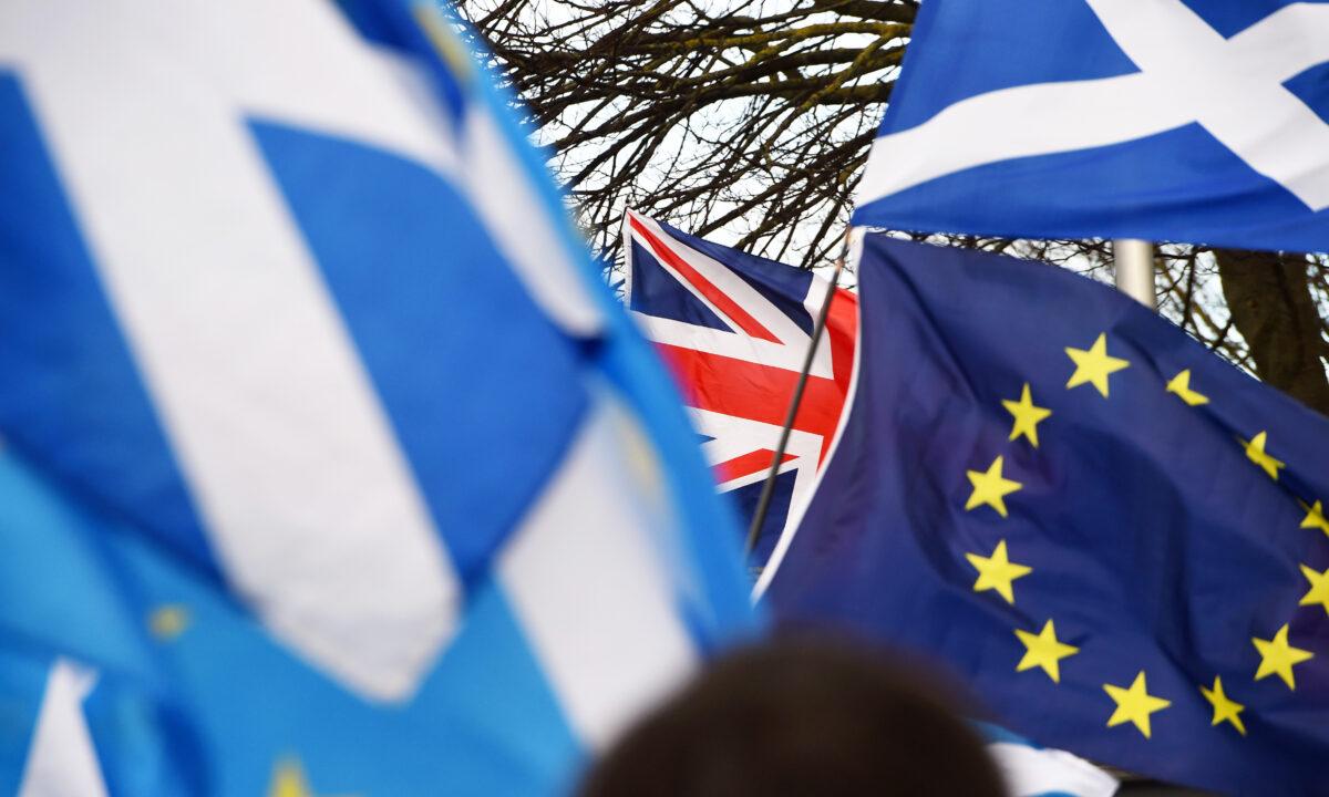 Pro-union activists wave a Union flag (C) as Scottish Saltire and EU flags fly during an anti-Conservative government, pro-Scottish independence, and anti-Brexit demonstration outside Holyrood, the seat of the Scottish Parliament in Edinburgh on Feb. 1, 2020. (Andy Buchanan/AFP via Getty Images)
