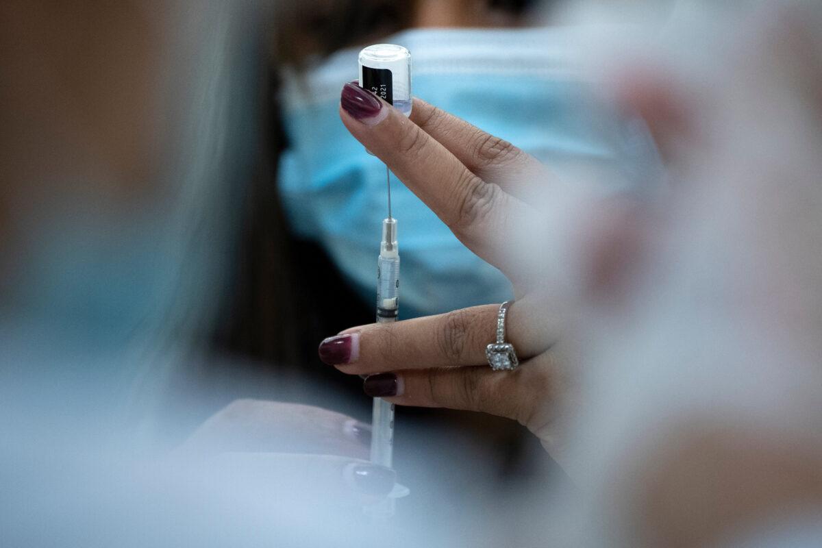 A pharmacist dilutes the Pfizer COVID-19 vaccine while preparing it to administer to staff and residents at the Goodwin House Bailey's Crossroads, a senior living community in Falls Church, Va., on Dec. 30, 2020. (Brendan Smialowski/AFP via Getty Images)