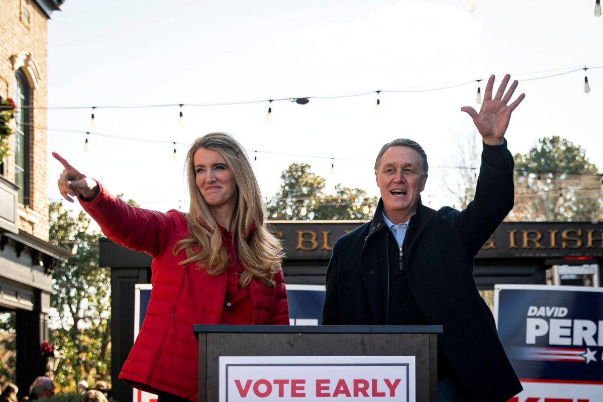 Sens. Kelly Loeffler (R-Ga.) and David Perdue (R-Ga.) wave during a campaign event in Milton, Ga., on Dec. 21, 2020. (Al Drago/Reuters)