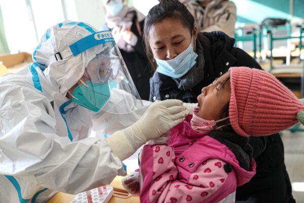A medical worker takes a swab sample from a child to test for COVID-19 in Shenyang, China, on Dec. 31, 2020. (STR/AFP via Getty Images)